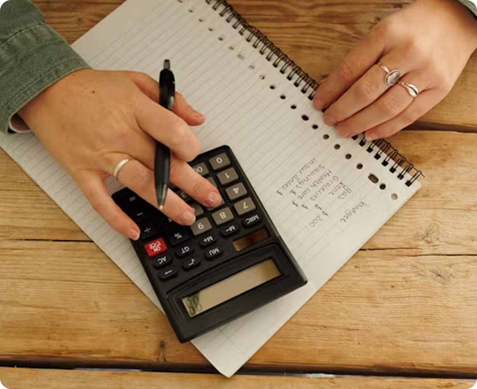 Hands using calculator with documents